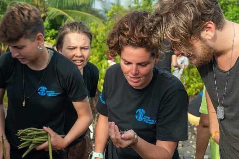 Young people learning about mangrove seeds with an MCP staff member